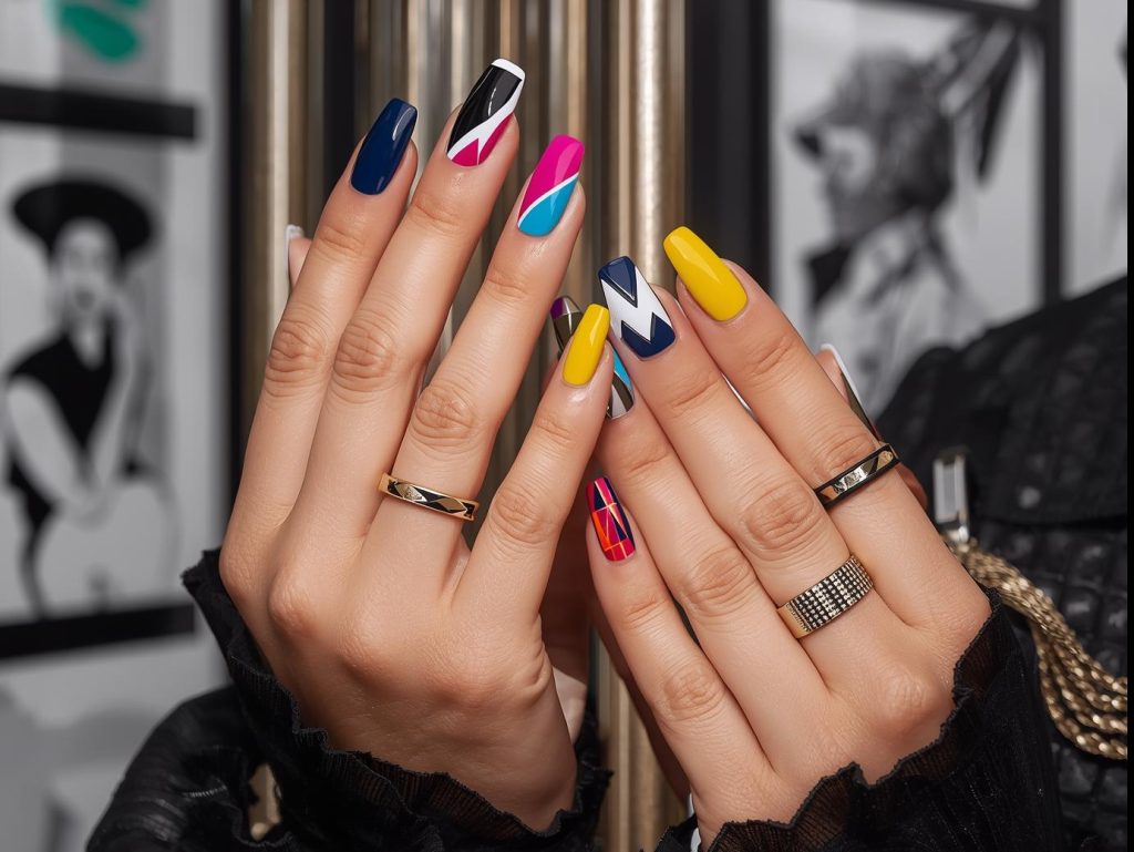 Geometric nail designs with black-white triangles, neon chevrons, gold-navy grids, and red-yellow hexagons for Pinterest inspiration.

