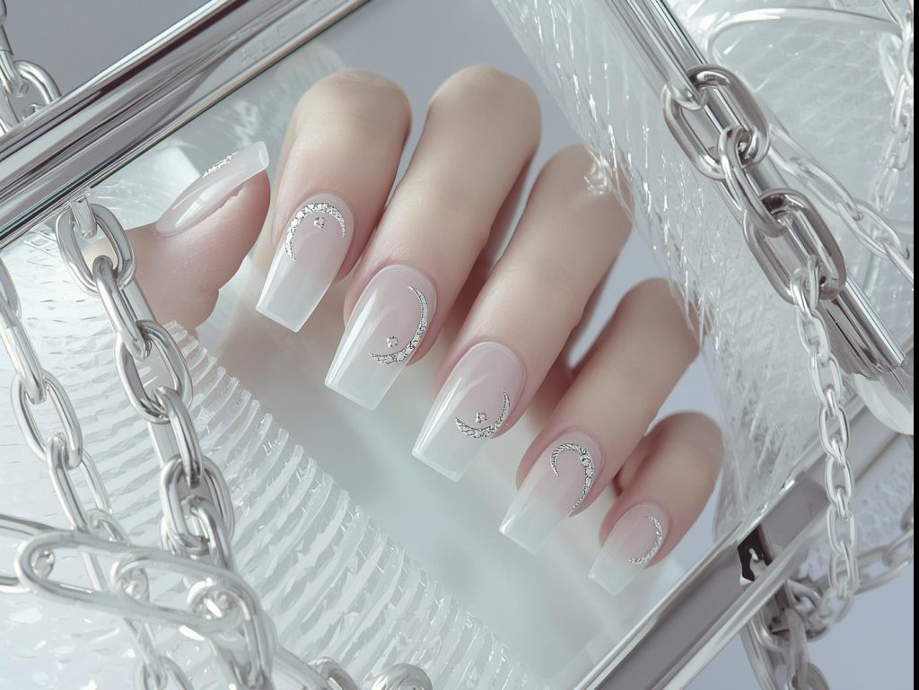 Clear nails with delicate silver crescent negative space nails with shimmering crescents.