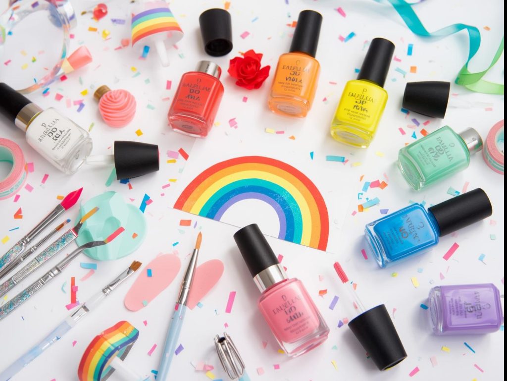 Nail art kit with polish and tools for rainbow nail designs.