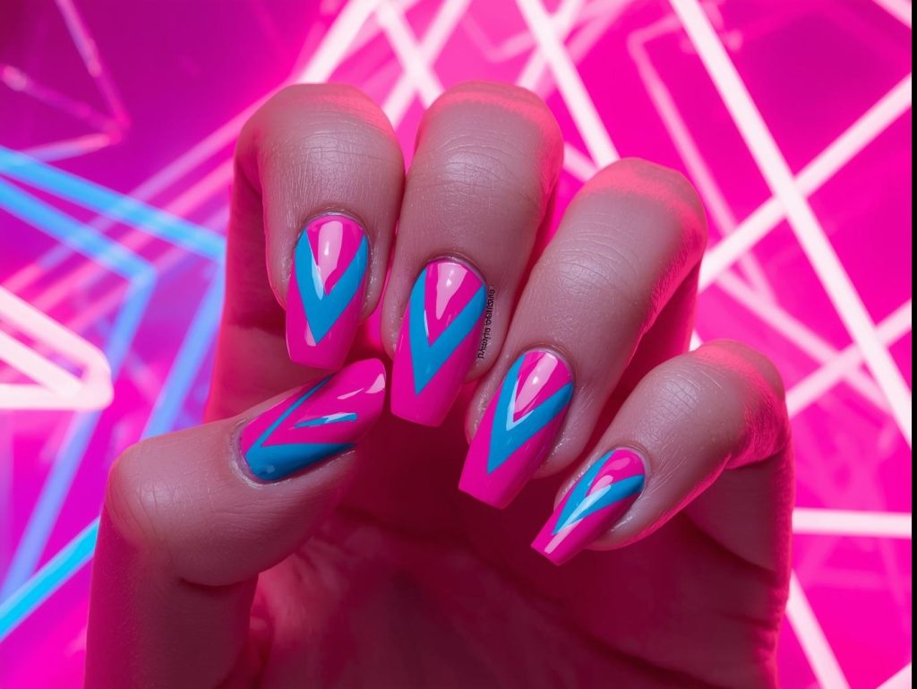 Vibrant neon pink and blue chevron geometric nails with zigzag patterns.