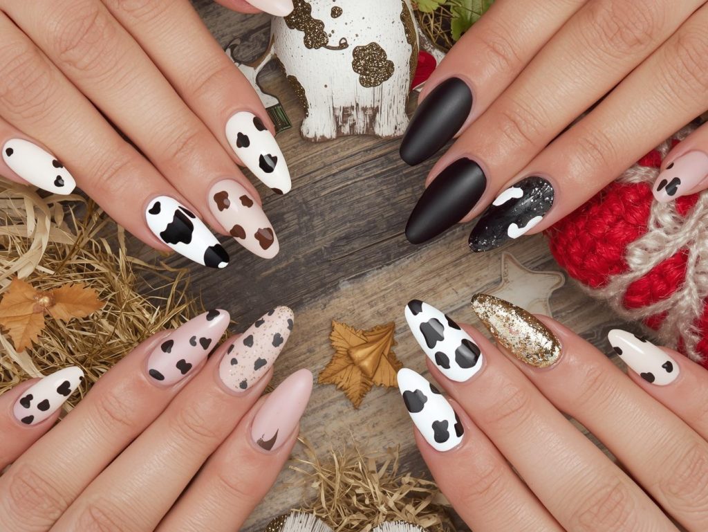 Cow Print Nail Designs: Playful and Pinterest-Worthy Manicures to Adore 2 Cow print nail designs with black cow spots, brown cow patches, white cow print accents, and gold cow spot details for captivating Pinterest inspiration.