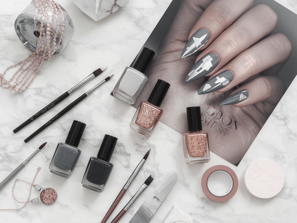 Nail art kit with polish and tools for grey nail designs.