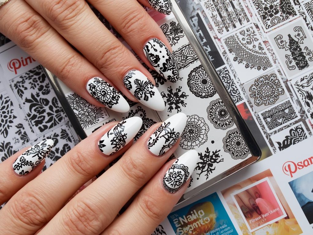 Glossy white black lace stamped nail design with white base on a Pinterest board.