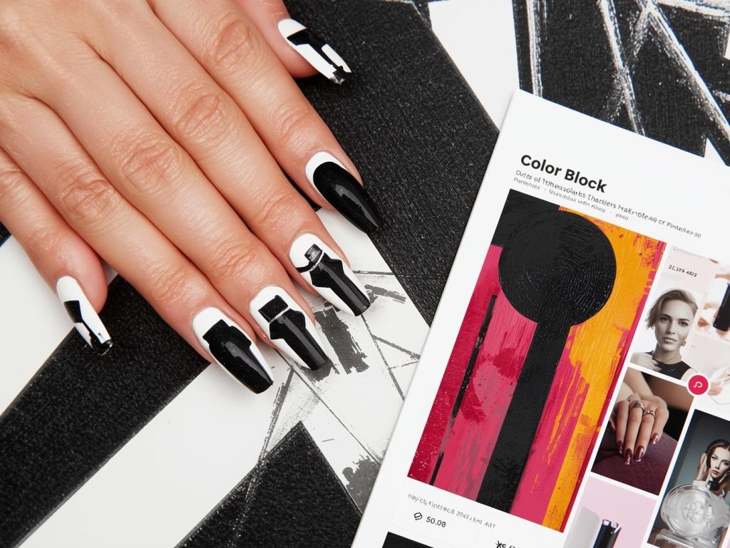 Glossy black and white color block nail art with silver accents on a Pinterest board.