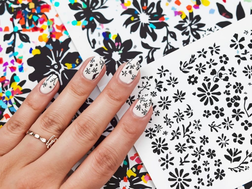  Glossy white black floral sticker nail design with white base on a Pinterest board.

