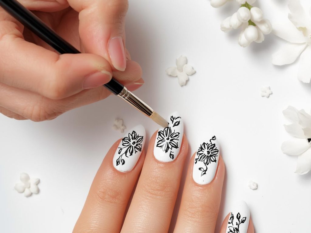  Creating glossy white black floral hand painted nail art with black floral designs.