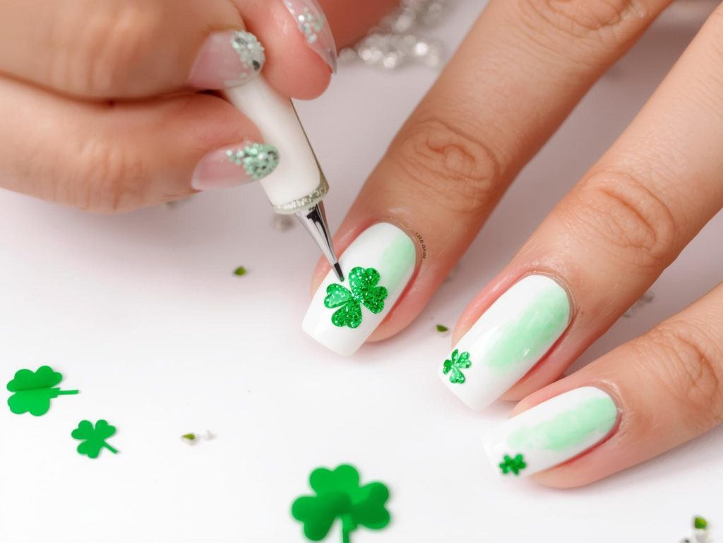 Creating white ombre green glitter clover nail art with green glitter details.