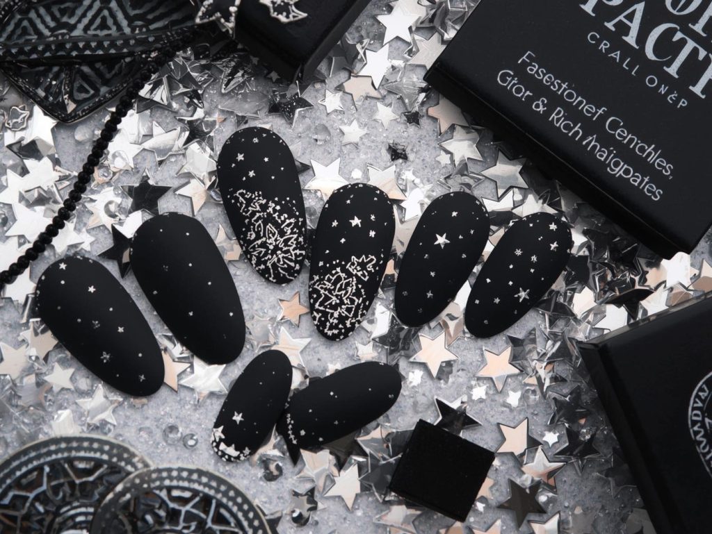 Applying matte black silver star press on nail art with silver star decals