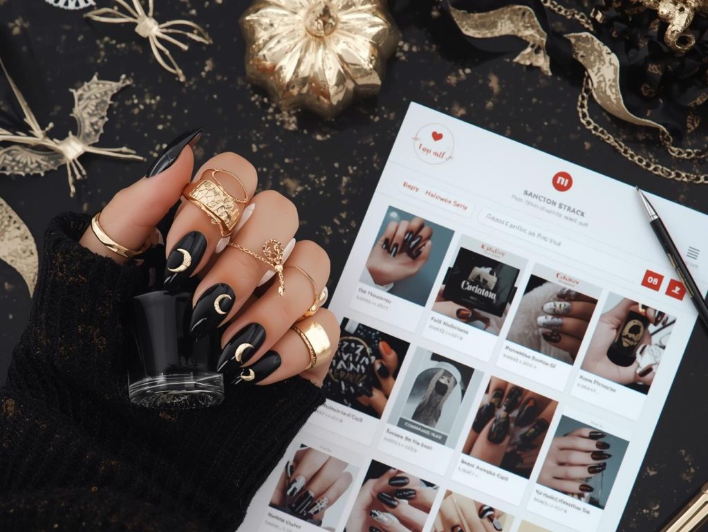  Glossy jet black crescent moon classy Halloween nail design with gold foil accents on a Pinterest board.