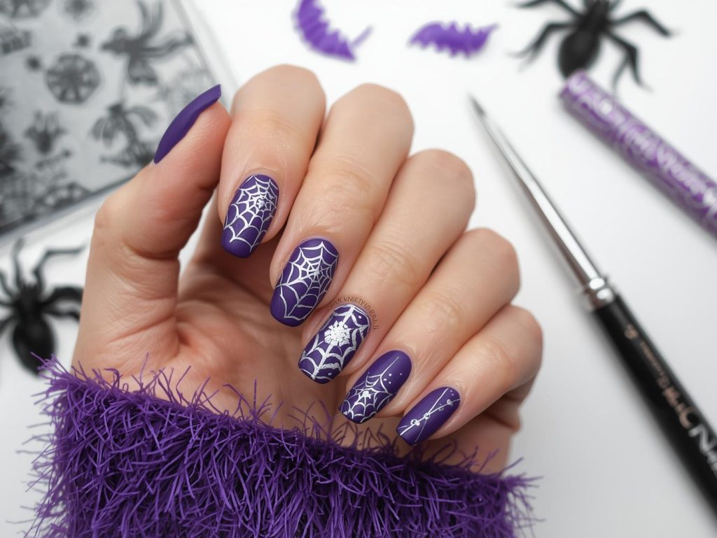 Applying matte purple silver spider web Halloween nail design with silver stamping