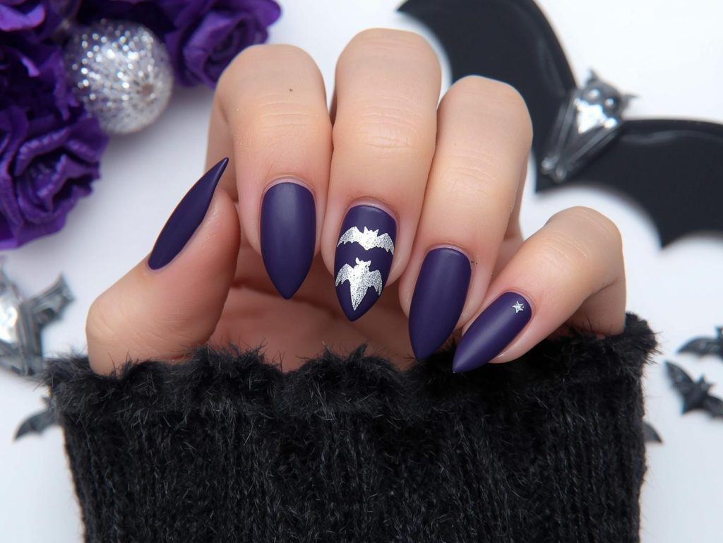 Halloween Acrylic Nails: Bold, Spooky, and Pinterest-Worthy Designs to Adore 8 Applying matte deep violet bat wing Halloween acrylic nail design with silver decals.
