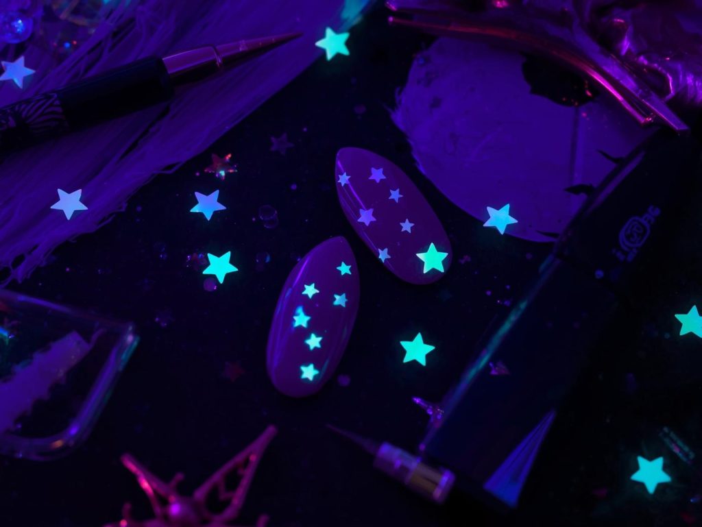Deep purple glow-in-the-dark star easy Halloween nail design with star stickers.
