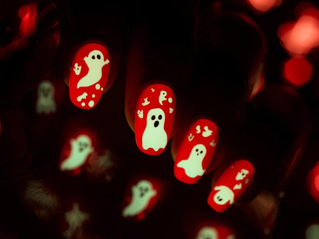 Blood red glow-in-the-dark ghost Kiss Halloween nail design with ghost stickers.