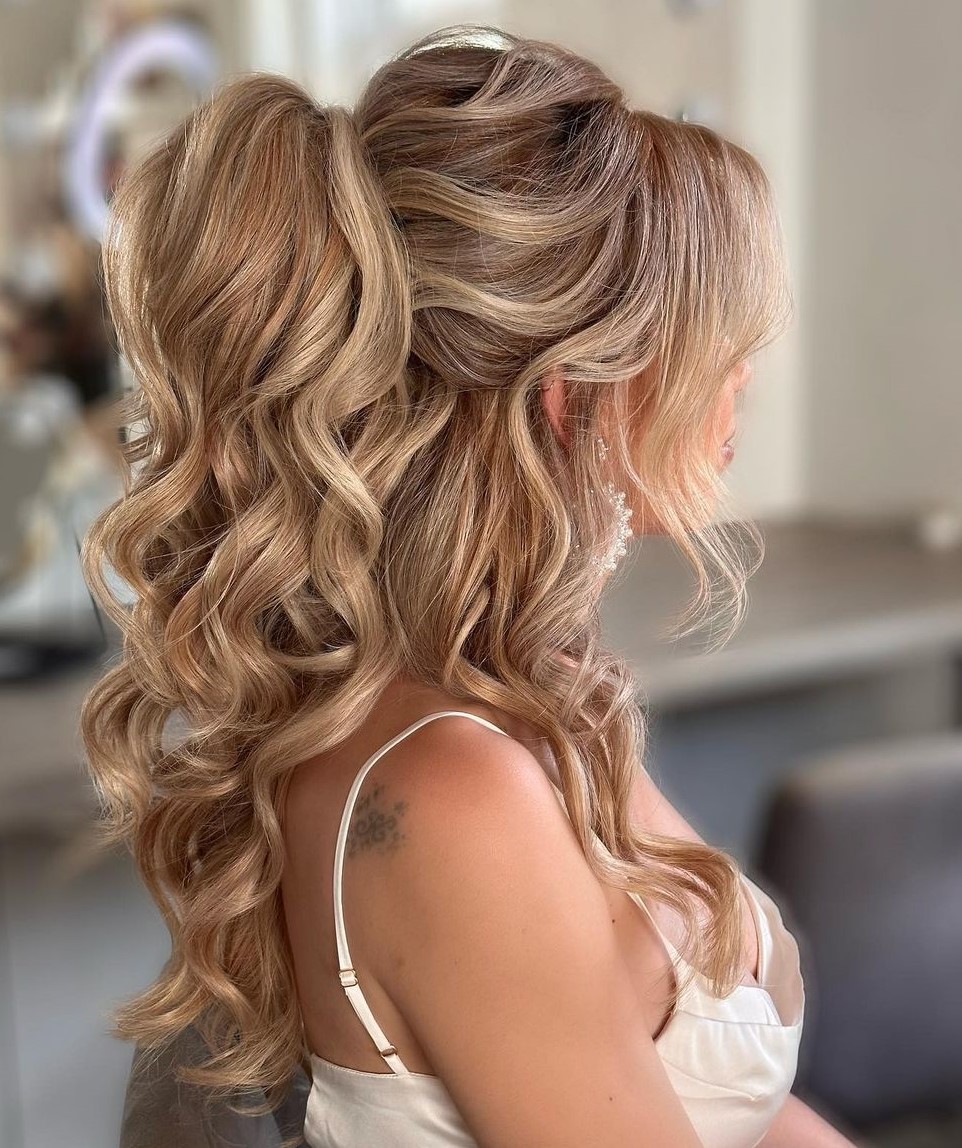  Half-up curly ponytail with voluminous texture for a playful aesthetic.